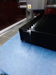 A PETG print of the box without anchors, showing significant warping and lifting off the bed.